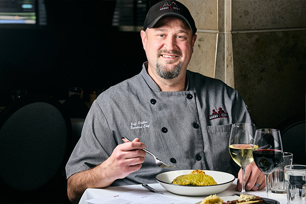 Chef Jeff Stoller in front of plate of food